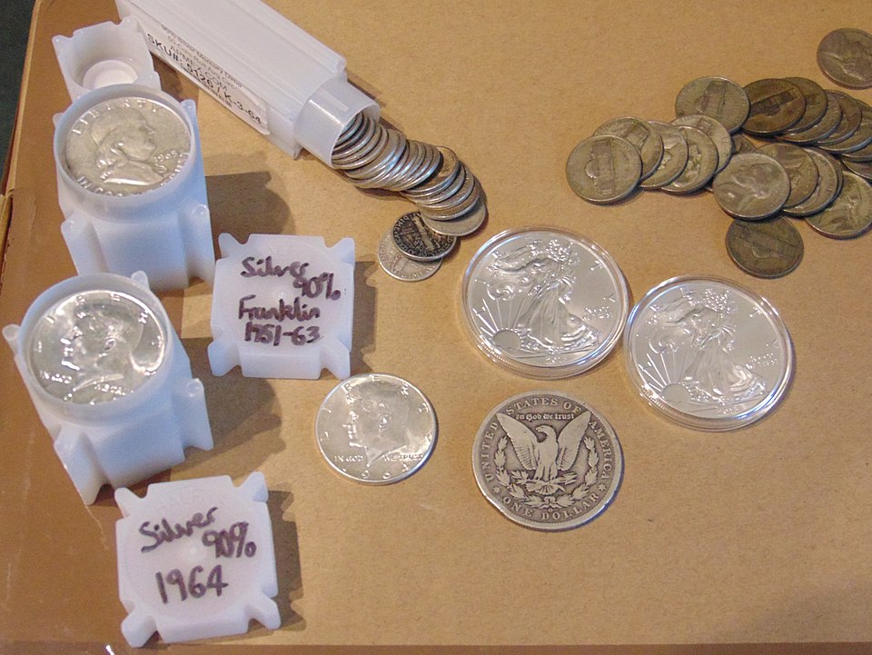 Roll of Mercury Dimes used for silver stacking alongside a digital scale showing silver weight