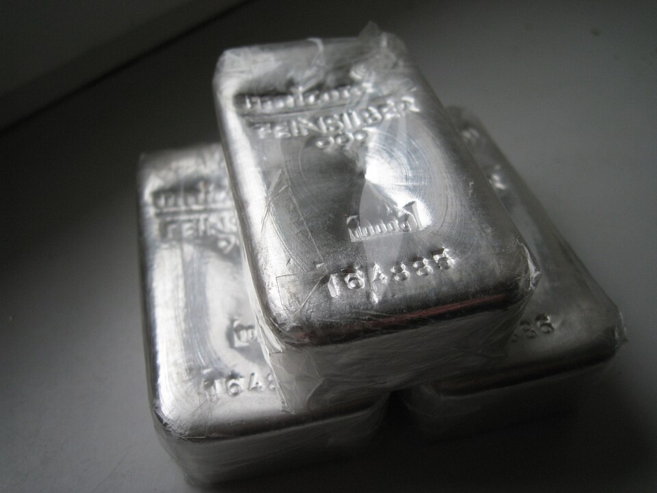 Stack of physical silver coins and bars demonstrating tangible silver ownership